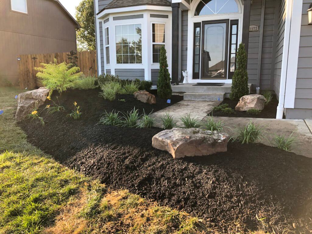 kansas city residential landscape that includes plants, boulders and mulch